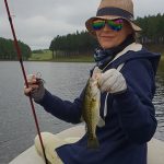 Little Scotland girl showing small bass caught from boat